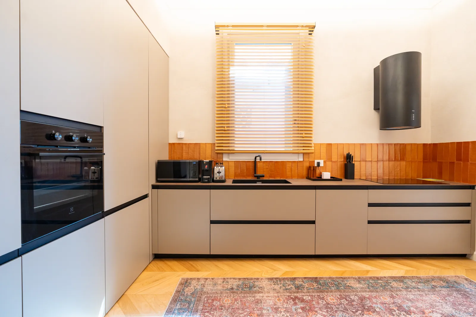 Piano cucina con forno, colonne grigie e finestra