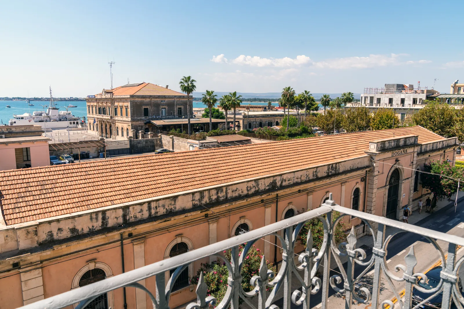 Tetti della Dogana, palme e mare visti dal balcone in ferro battuto